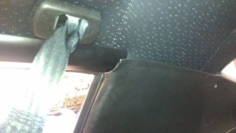 1973 Chevrolet Camaro - A view of a car's interior, focusing on the headliner and a seatbelt mechanism.