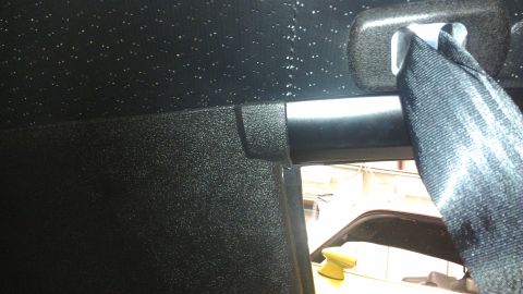 1973 Chevrolet Camaro - Close-up of a black seatbelt and textured headliner, showing the detail of the interior trim.