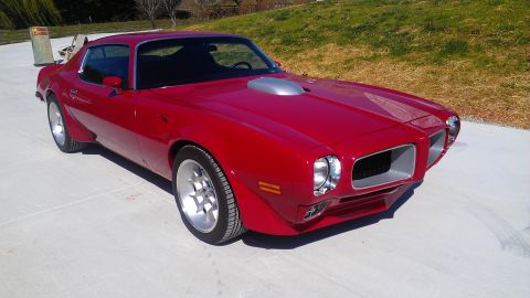 1972 Pontiac Trans Am - This red Pontiac Firebird has a distinctive shaker hood scoop and custom wheels.