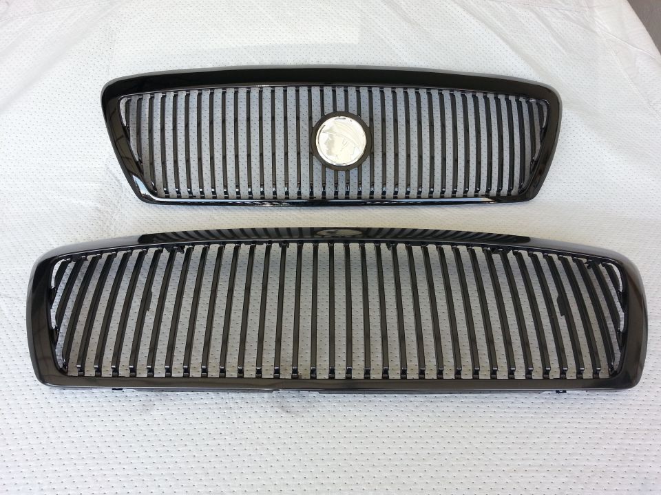 Two black vertical-bar aftermarket grilles for a Ford Crown Victoria displayed on white cloth