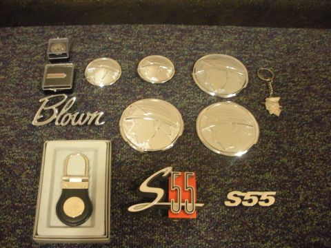 2003 Mercury Marauder - A display of various car emblems and a keychain, including the script 'Blown' and the 'S55' badge.