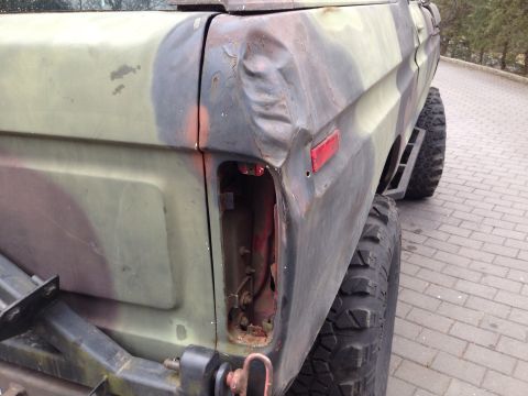 1979 Ford Bronco - Rear view of a 1979 Ford Bronco with camouflage paint and body damage.