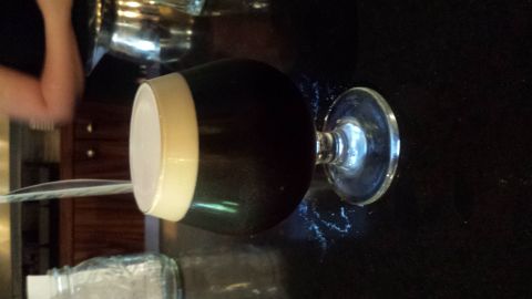 1996 Ford Bronco - A glass of dark beer with a white head is presented on a dark surface.