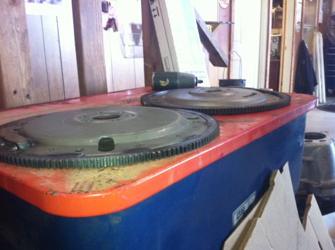 1982 Ford Bronco - Two flywheel assemblies are visible on a workbench, with a "Supermotors.net" logo in the lower right corner.