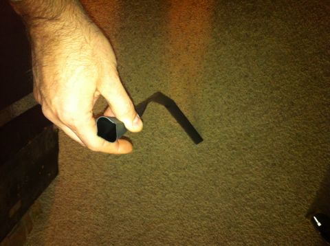 1982 Ford Bronco - A hand holds a bent metal pipe against a carpeted surface. Text from Supermotors.net is visible.