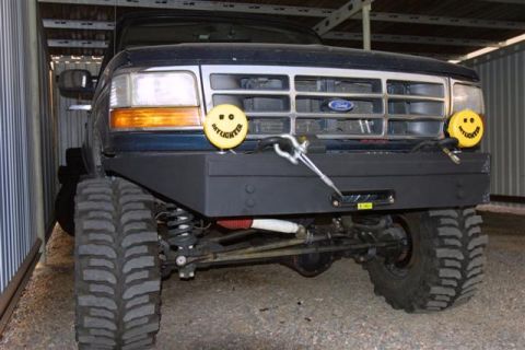 1994 Ford Bronco - This Ford truck features a custom bumper and off-road tires, with distinctive yellow lights on the front.