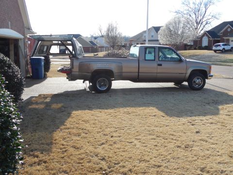 1997 Chevrolet Silverado 3500 - It's on the bedrails to keep it from tipping in the breeze, but the camper's weight is entirely on the crane, which still swings easily.