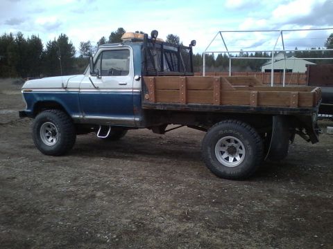 1973 Ford F-250 - This Ford F-250 flatbed truck features a custom wooden bed and a rear rack, likely for hauling equipment.