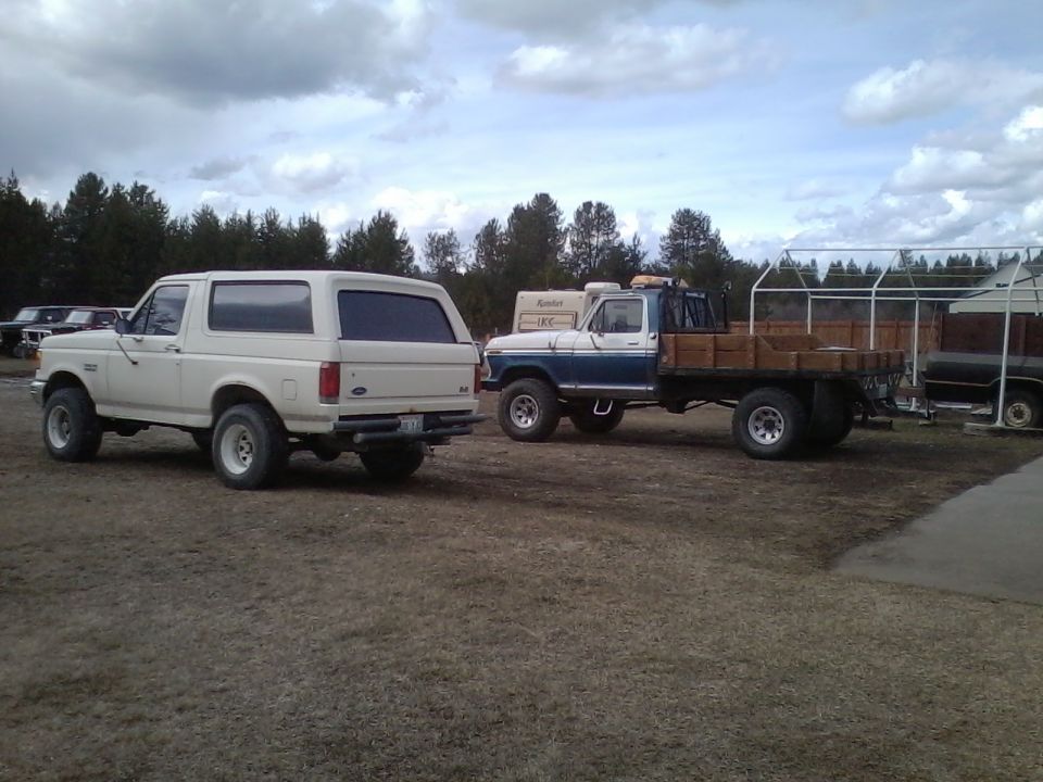 White Ford Bronco, rear view, parked on dirt lot