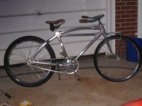 Chrome bicycle with brown leather seat and grips, side view