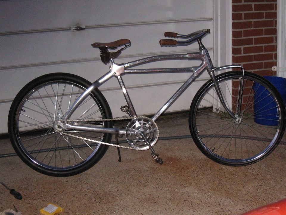 Chrome bicycle with brown leather seat and grips, side view