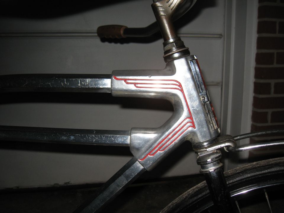 Chrome bicycle frame with red pinstriping and a brown handlebar grip