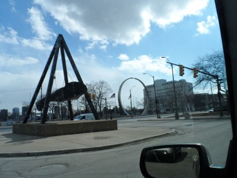 1971 Ford Ranchero - View of a city street with public art installations including a large swing-like sculpture and a circular sculpture.