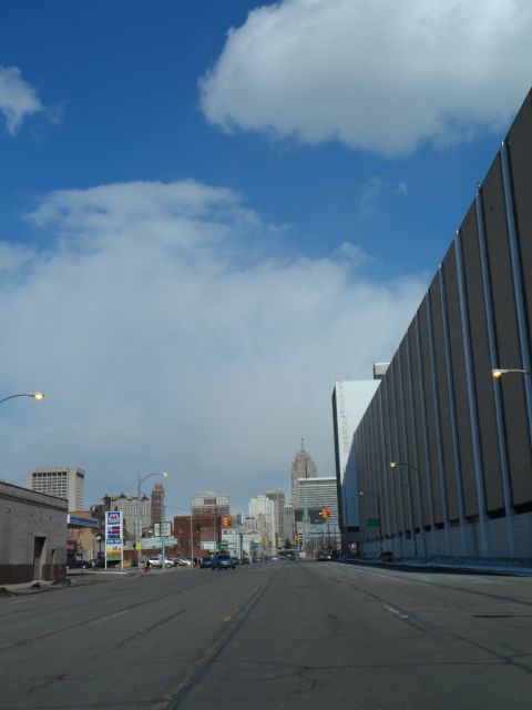 1971 Ford Ranchero - A city street stretches towards a skyline under a blue sky with scattered clouds.