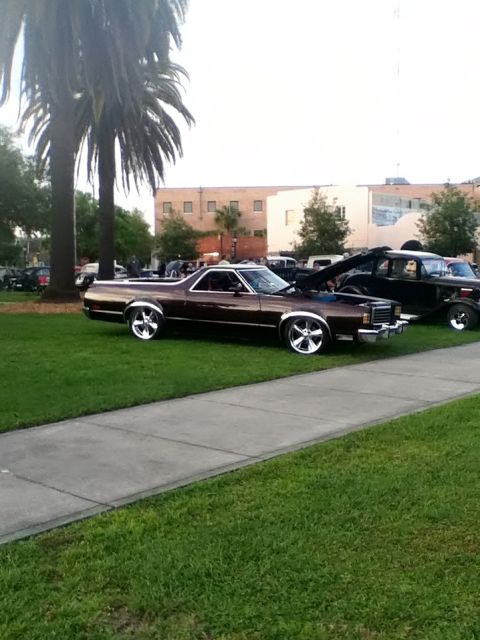 1979 Ford Ranchero - Dark metallic brown Ford Ranchero car-based pickup parked on grass at an outdoor car show, shown from the driver's side slightly rear-of-ce…