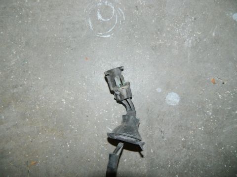 1979 Ford Bronco - This image shows an electrical connector and wiring harness lying on a concrete surface.