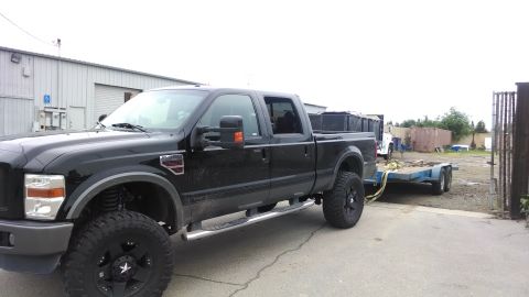 1985 Jeep CJ7 - Black Ford F-350 Super Duty pickup truck towing a trailer.