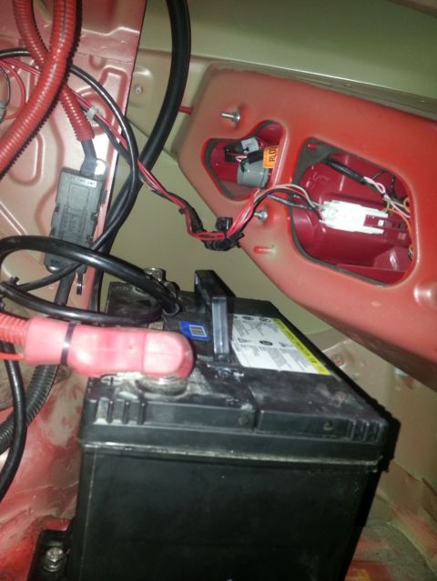 2010 Hyundai Genesis - Close-up view of a car battery and its associated wiring within the vehicle's chassis.