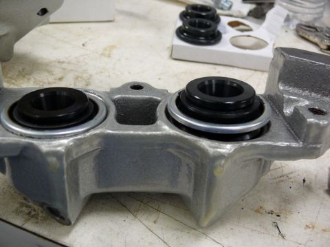 Close-up of a brake caliper with two black rubber seals installed