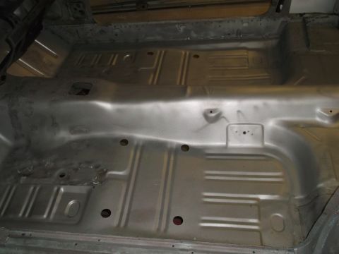 1967 Ford Mustang - The bare metal floor pan of a classic car interior, showing structural details and mounting points.
