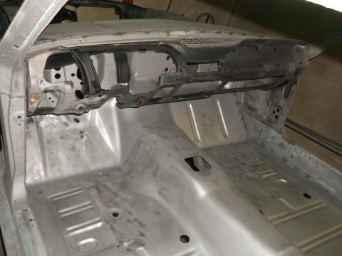 1967 Ford Mustang - Interior of a 1967 Ford Mustang stripped for restoration, showing bare metal floor and dash structure.