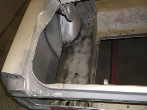 1967 Ford Mustang - Close-up of the trunk interior of a 1967 Ford Mustang, revealing bare metal, primer, and repair work.