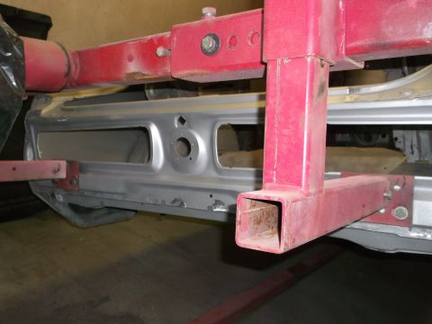 1967 Ford Mustang - Car frame section with red metal support structure during repair or restoration.