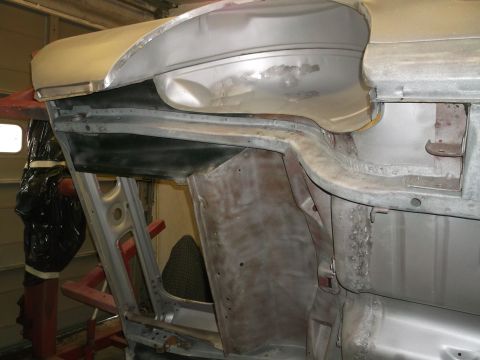 1967 Ford Mustang - The underside of a car body is shown during repair work, revealing its internal structure and metal panels.