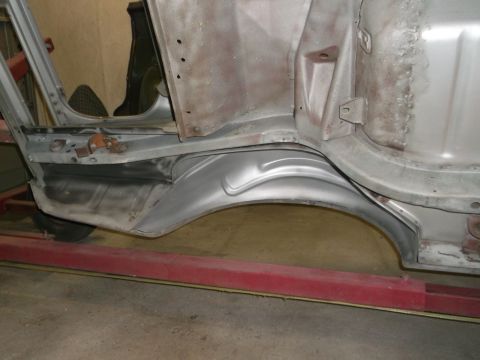 1967 Ford Mustang - Close-up view of a car's bare metal body panel and wheel well during restoration.