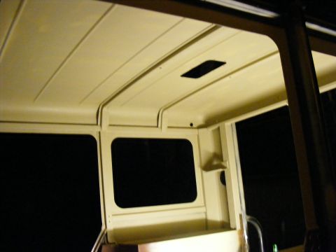 Interior shot of a vehicle's headliner and side window frame. There's a rectangular vent in the headliner