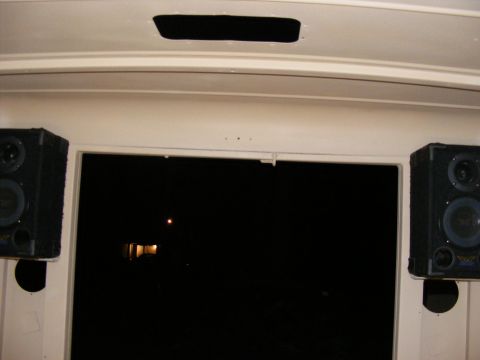 Interior view showing two speakers mounted near a dark window with a faint light reflection