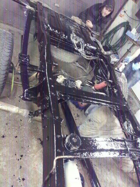 1995 Ford F-150 - Vehicle frame undergoing painting and maintenance in a workshop setting.