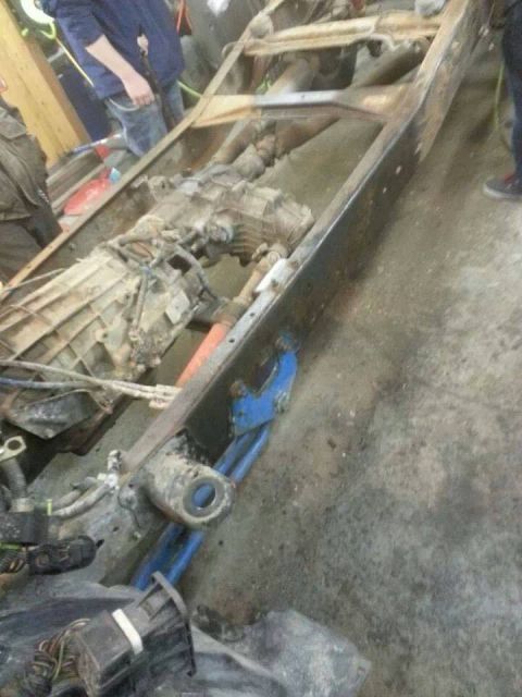 1995 Ford F-150 - The frame and drivetrain of a truck are shown, with a transmission and other mechanical parts in view.
