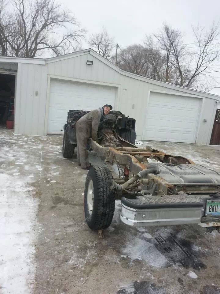 1995 Ford F-150 chassis with engine being worked on, in front of a garage