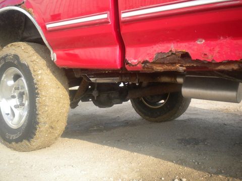 1995 Ford F-150 - This 1995 Ford F-150 shows significant rust along its lower body panels and a mud-covered tire.