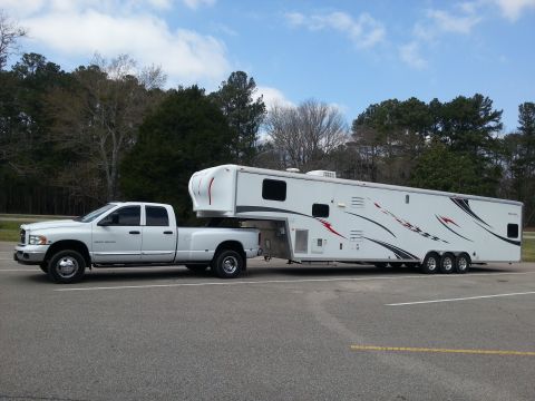 1967 Ford Mustang - A white Dodge Ram 3500 dually pickup truck is seen from the side, towing a large white fifth-wheel trailer.