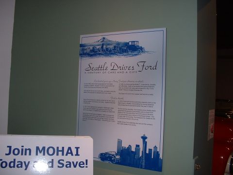 1999 Ford Crown Victoria - A historical document about Ford's presence in Seattle, displayed in a museum setting.