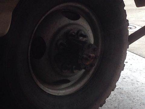 1988 Ford F-350 - Detail of a truck's wheel hub and tire, showing the lug nuts and the tire tread.