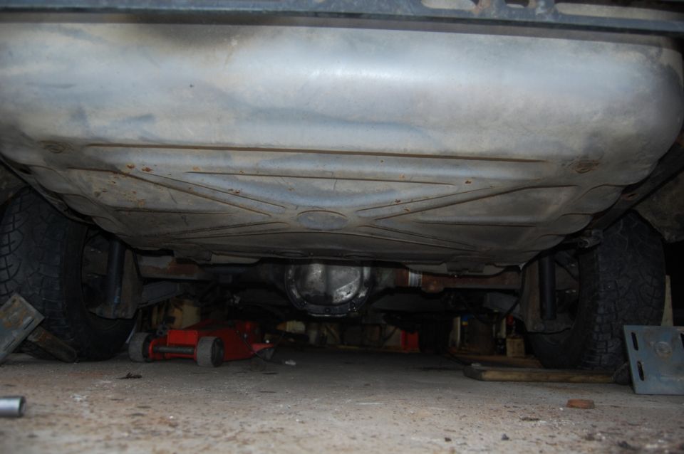 Underside view of a car showing fuel tank and rear differential