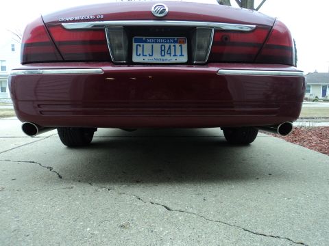 2004 Mercury Grand Marquis - The rear of a 2004 Mercury Grand Marquis, its taillights, chrome bumper accents, and dual exhaust pipes.