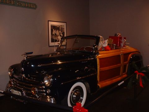1999 Ford Crown Victoria - This woodie wagon, likely from the late 1940s, is decorated for the holidays with gifts and a Santa figure in the rear.
