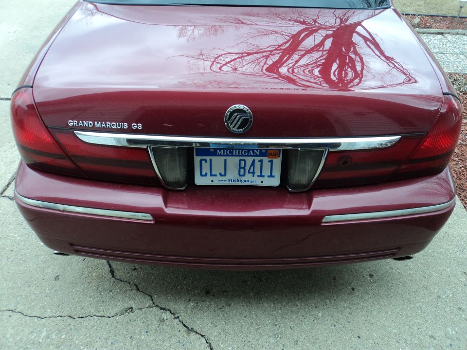 Rear of a red Mercury Grand Marquis GS with a Michigan license plate CLJ 8411