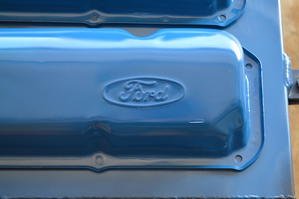 Close-up of blue painted Ford valve covers with embossed Ford oval logo