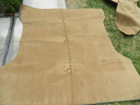 1979 Ford Bronco - A tan carpet mat, likely for a vehicle's interior, is laid out on concrete and grass.