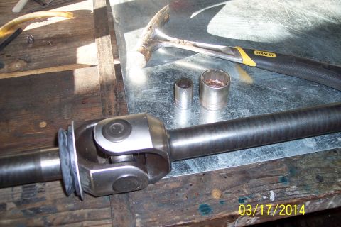 1973 Ford F-250 - A driveshaft universal joint is shown with tools on a workbench, suggesting a repair or maintenance task.