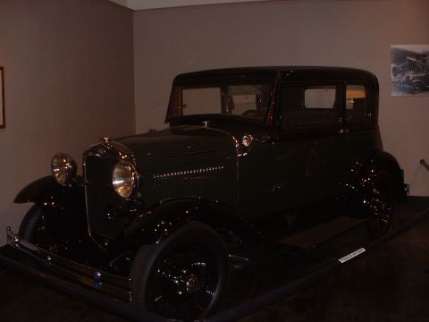 1999 Ford Crown Victoria - This vintage Ford Model A sedan is displayed indoors, likely in a museum or showroom.