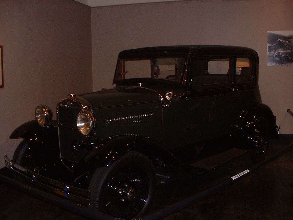 Dark green 1930s Ford Model A sedan parked indoors