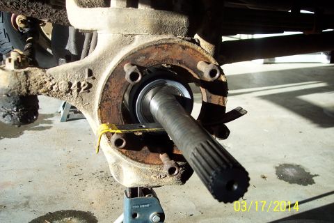 1973 Ford F-250 - Close-up view of a vehicle's front knuckle-joint assembly, showing the splined axle shaft and bearing components.