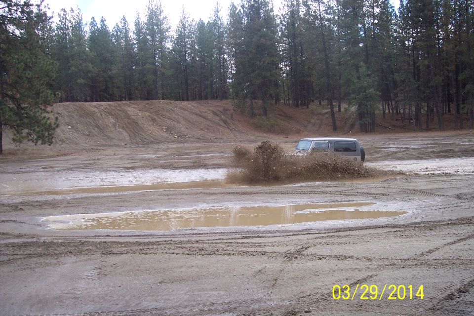 SUV splashing through mud puddle, side view