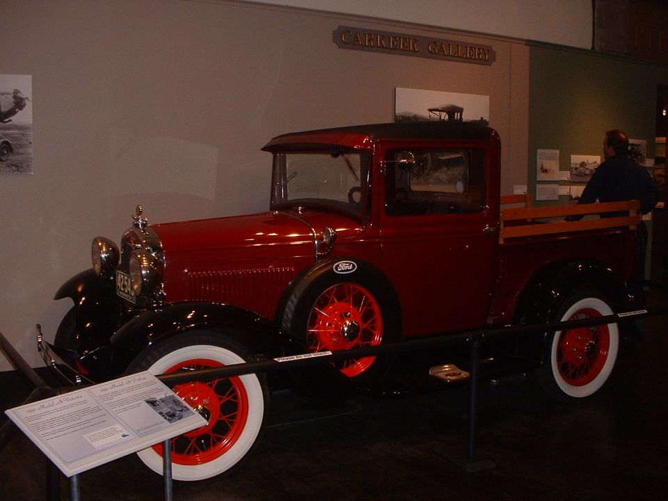 Red pickup truck with wooden bed and red wheels
